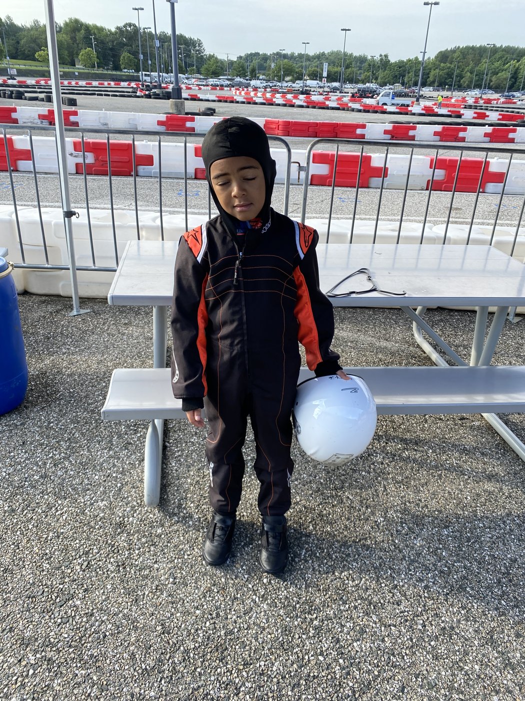 Kaz at the track early in his karting days, helmet in hand
